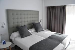 a bedroom with a large bed and a large window at Estudiotel Alicante in Alicante