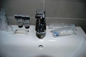 a bathroom sink with a toothbrush, toothpaste, and toothpaste dispens at Estudiotel Alicante in Alicante