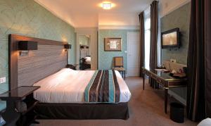 a hotel room with a bed and a desk at Grand Hôtel de Tours in Tours