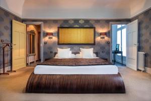 a bedroom with a large bed in a room at Grand Hôtel de Tours in Tours