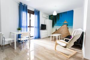 a living room with a beach scene on the wall at C&V Apartamentos - Horno de Marina in Granada
