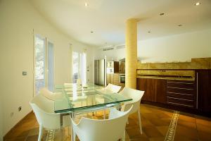 Un comedor con una mesa de cristal y sillas blancas. en Villa Narcis, en Alcudia