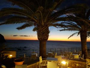 un restaurante con vistas al océano al atardecer en Hotel Terme Royal Palm, en Isquia
