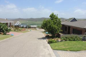 a street in a residential neighborhood with a house at Traveller's Rest, Reebok in Mossel Bay