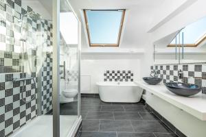 a bathroom with two sinks and a tub at Grand Hôtel de Tours in Tours