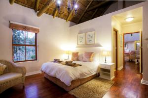 a bedroom with a bed and a couch and a chair at Hogsback Arminel Hotel in Hogsback