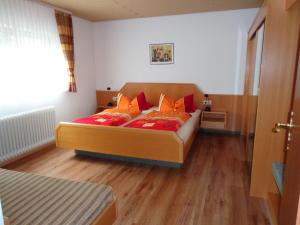 1 dormitorio con 1 cama con almohadas de color naranja en Haus am Weinberg, en Endingen am Kaiserstuhl