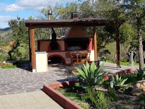 um gazebo com uma mesa e uma lareira em Villa Carmen em Cardedu