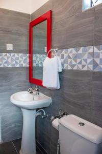 a bathroom with a sink and a mirror and a toilet at Serene Homes in Mombasa