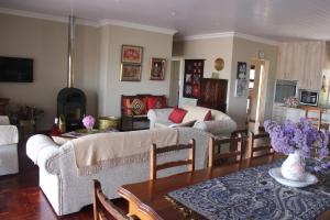 a living room with two couches and a table at Traveller's Rest, Reebok in Mossel Bay