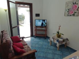 a living room with a couch and a tv at Villetta Residence Chiusurelle in Porto Cesareo