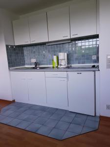 uma cozinha com armários brancos e uma bancada em Ferienwohnung Nordwind em Cuxhaven