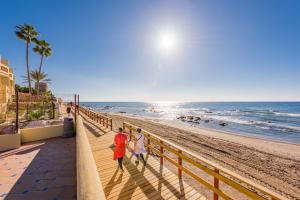 a couple walking along the beach at Macdonald Doña Lola Resort in La Cala de Mijas