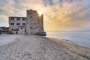ein altes Gebäude am Strand bei Sonnenuntergang in der Unterkunft Relais Torre Mozza - Dimora d' Epoca in Follonica