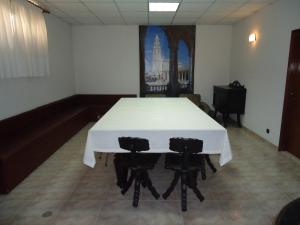 een witte tafel met vier stoelen in een kamer bij Residencial Coroa D'Ouro in Fátima