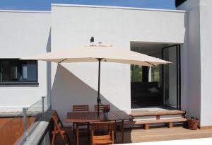 聖塞巴斯提安的住宿－Plena naturaleza en Pleno San Sebastián，天井配有带雨伞的桌子