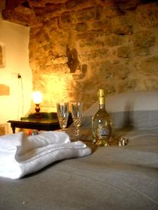 a bottle of wine and two glasses on a table at Guesthouse Runcini in Ferentillo