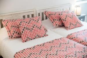2 camas con almohadas rojas y blancas en Casas do Norte, en Ericeira