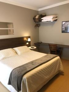 um quarto com uma cama, uma mesa e uma cadeira em Stefano Hotel em São Roque