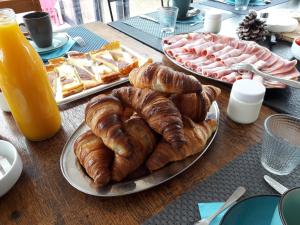 una mesa con cruasanes y otros bollería y zumo de naranja en Villa Angel - SPA, en Caunes-Minervois