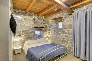 a bedroom with a bed and a stone wall at Holiday Home Ruža in Gračišće