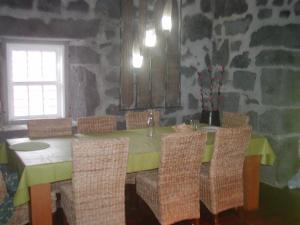 a dining room with a table with chairs and a window at Casa da Ermida in Velas