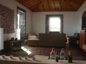 a living room with a couch and a table at Casa da Ermida in Velas