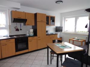 une cuisine avec des placards en bois et une table ainsi qu'une salle à manger dans l'établissement Haus am Weinberg 2, à Endingen am Kaiserstuhl