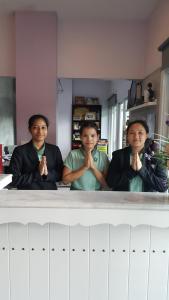 a group of three men praying in front of a counter at Ricco Suvarnabhumi in Bangkok