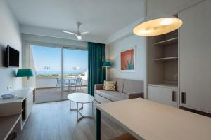 een woonkamer met een bank en een tafel bij SBH Maxorata Resort in Morro del Jable