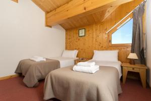 A bed or beds in a room at Madame Vacances Les Chalets du Praz