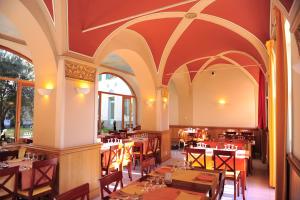 a restaurant with tables and chairs in a room at Le Prieuré in Saint-Dalmas-de-Tende