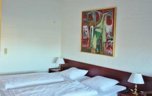 a bedroom with two beds and a painting on the wall at Sølyst Kro- Restaurant og Hotel I/S in Aabenraa