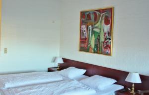 a bedroom with two beds and a painting on the wall at Sølyst Kro- Restaurant og Hotel I/S in Aabenraa