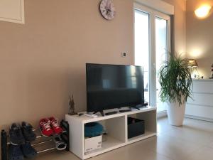 - une télévision à écran plat installée sur un support blanc dans le salon dans l'établissement Studio Apartments Santa, à Marčići