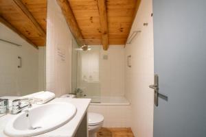 un baño con lavabo e inodoro en Casa de los Curas, chimenea 2 Hab 4 Pers Max, en Puerto de la Laja 37 fotos más