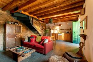 - un salon avec un canapé rouge et une table dans l'établissement Casa de los Curas, chimenea 2 Hab 4 Pers Max, à Puerto de la Laja
