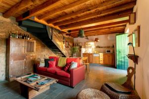 a living room with a red couch and a table at Casa de los Curas, chimenea 2 Hab 4 Pers Max in Puerto de la Laja