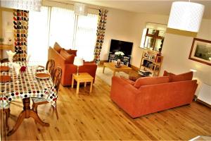 a living room with two couches and a table at Rosewood Cottage in Galway