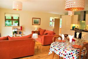 a living room with couches and a table and a kitchen at Rosewood Cottage in Galway