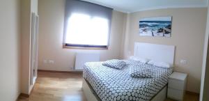 1 dormitorio con cama y ventana en Precioso apartamento en Sanxenxo, en Sanxenxo