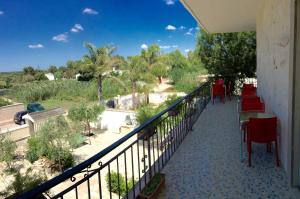 a balcony with tables and chairs and a view of a park at La Palude del Conte in Punta Prosciutto +41 photos