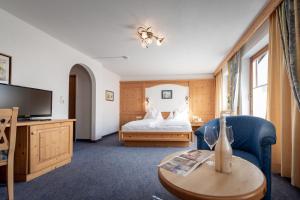 een hotelkamer met een bed en een salontafel bij Hotel Alpenrose in Pertisau