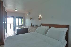 una camera da letto con un grande letto bianco e un lavandino di CASA MARAVILHOSA à BEIRA MAR EM ANGRA DOS REIS ad Angra dos Reis Altre 39 foto