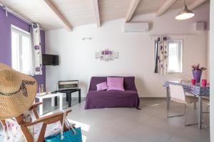 ein Wohnzimmer mit einem lila Sofa und einem Tisch in der Unterkunft Casa Zefiro in Pozzallo