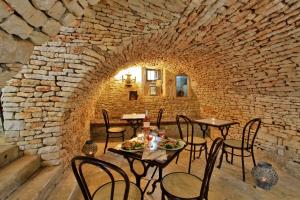 スイヤックにあるDomaine de La Paille Basseの石壁のテーブルと椅子のあるレストラン