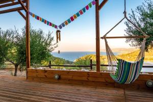 eine Hängematte auf einer Terrasse mit Meerblick in der Unterkunft Auberge Kalopetri in Kamiros