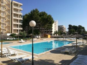 a large swimming pool with chairs and umbrellas at Apartamento Salou, playas, piscina in Salou