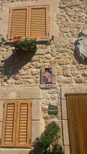 ein Steingebäude mit Fenstern und einer Schachtel darauf in der Unterkunft Casa Rural con encanto en Las Arribes Abuelo Román in Masueco