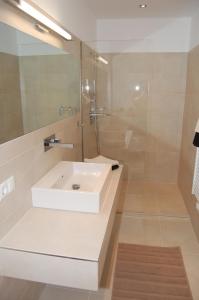 a bathroom with a white sink and a shower at WS-Appartement in Kitzbühel